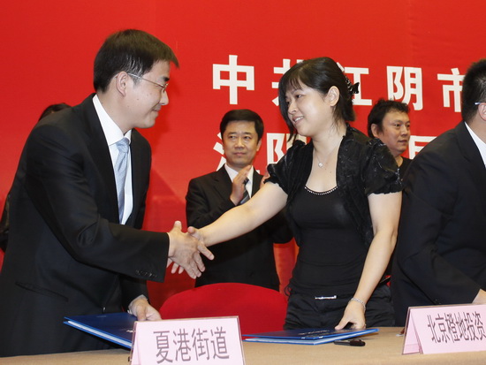 伊橙天娱乐副总裁伊简梅(右)与夏港街道代表签