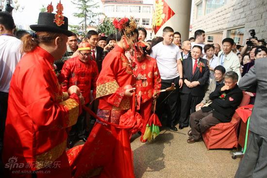 新浪娱乐讯 4月28日,赵本山唯一的洋弟子博比肯与女导演张雯婷在北京举行了婚礼。赵本山作为男方家长出席,为弟子的婚礼支撑门面。同时,婚宴以及来宾的食宿均有赵本山埋单,并给了弟子一个丰厚的红包作为贺礼。图为新郎新娘牵绣球 。杨申/文 郑福德/图