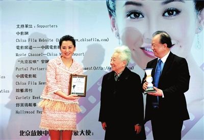 　　于蓝（中）、李前宽（右）向许晴（左）授“第十五届北京放映中国电影形象大使”证书和奖杯。　本报记者张伟摄