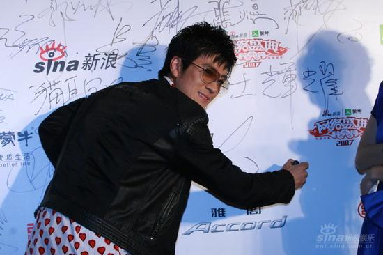 图文:杨子在背景板上签名 墨镜配黑夹克帅气