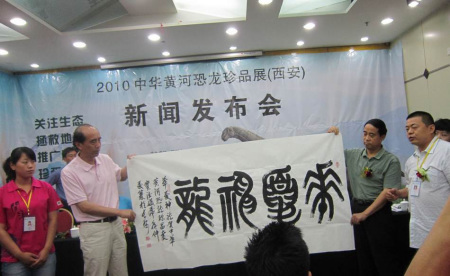 图为 国内著名大篆书法家窦德盛（右二）为恐龙展赠书法珍品
