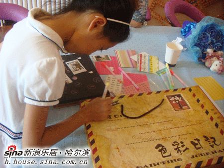 图为正在书写相册名称的小女孩