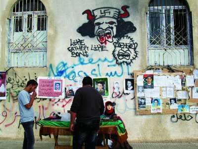 在班加西解放广场的墙上,到处都是反对派讽刺卡扎菲的涂鸦。