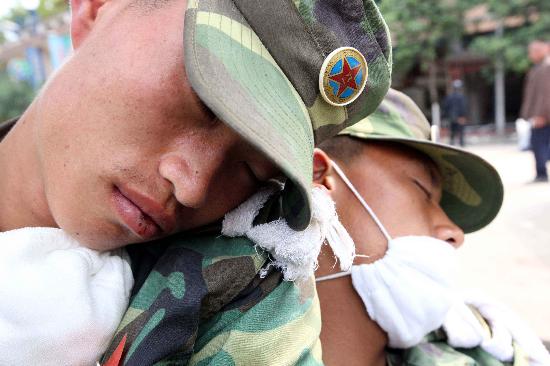 5月16日,疲劳不堪的两位解放军战士在路边稍作休息