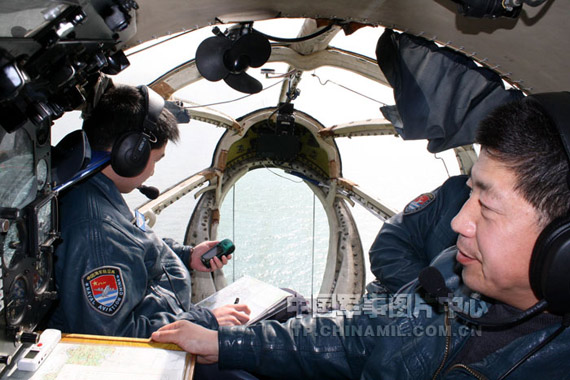 战机在降低高度超低空飞行过程中，领航员在忙碌地向驾驶员报告战机航向、高度等姿态的场景