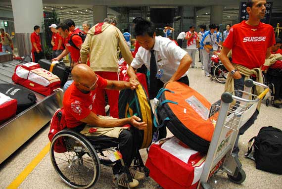 国航工作人员协助残奥旅客将托运行李装车