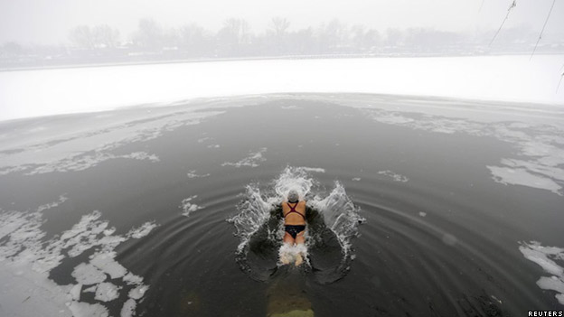 Swimmer plunging into a frozen lake