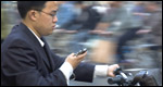 A man texting on a scooter