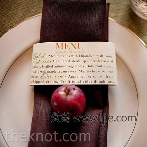 餐盤挑選了有金色邊框的白色陶瓷盤，外面搭配了深棕色的餐巾和婚禮的菜單，同時還別有創意的放了一個蘋果，很有秋天的田園感。