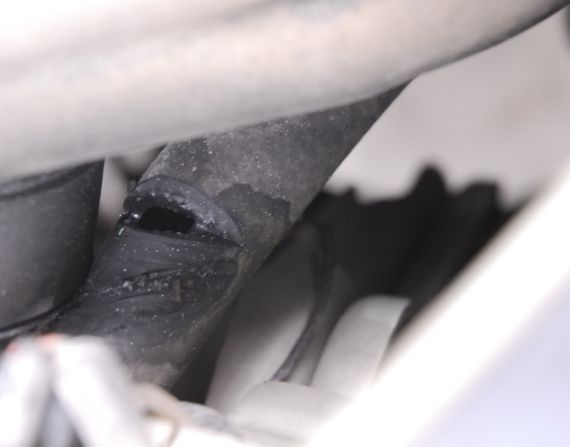 发动机舱内，一根胶皮管线被锐物“切割”，位置靠近断裂的发动机支架。