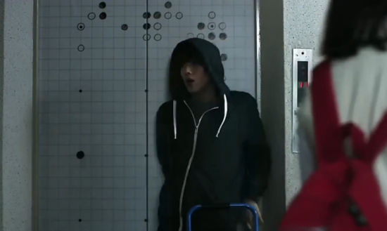 电影截图：男主角在电梯门棋盘上与人隔空对弈
