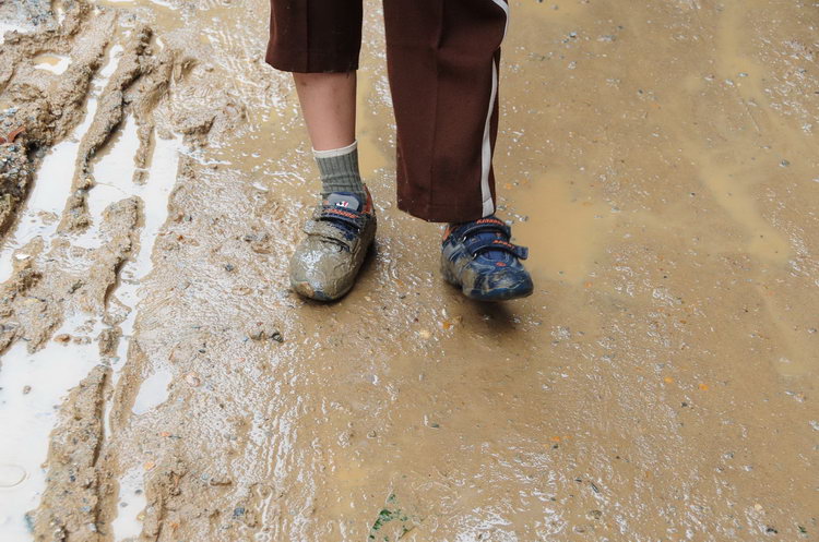 小孩雨靴踩泥陷入淤泥图片