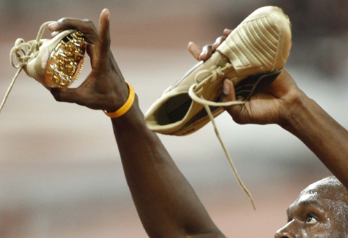 博尔特在刷洗百米纪录夺冠后展示黄金跑鞋,还不忘伸出手指说一声我是