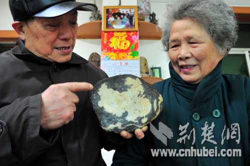 奇石收藏老人郑方炎和他的老伴一起欣赏中国地图石