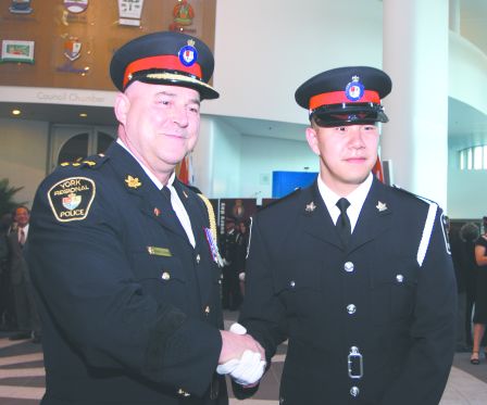 李浩然在毕业礼上与约克区警察总长乐巴治握手.