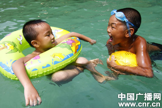 兩名小男孩在柳城縣沙埔鎮一旅遊景點的泳池內戲水