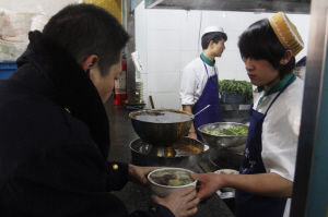 一市民接过一碗香喷喷的牛肉面