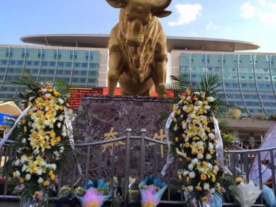 在事发的昆明火车站广场前巨大的"奔牛"雕塑下,昆明市民敬摆花圈和