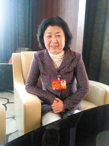 驻地,全国政协委员,玖龙造纸有限公司董事长张茵接过助手递过来的梳子