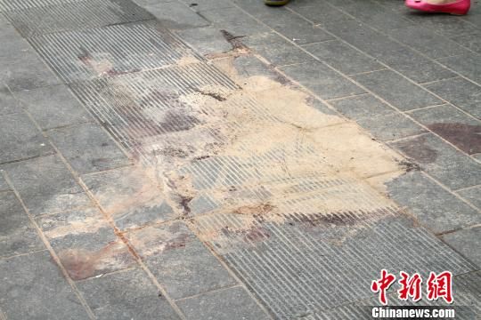 图为火车站广场案发地的血迹,已被沙土掩盖 记者 张远 摄