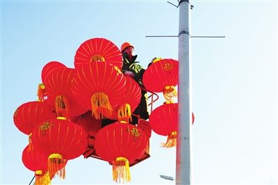 2月13日,銀川市路燈管理處在北京路等城市主幹道的路燈上懸掛大紅燈籠