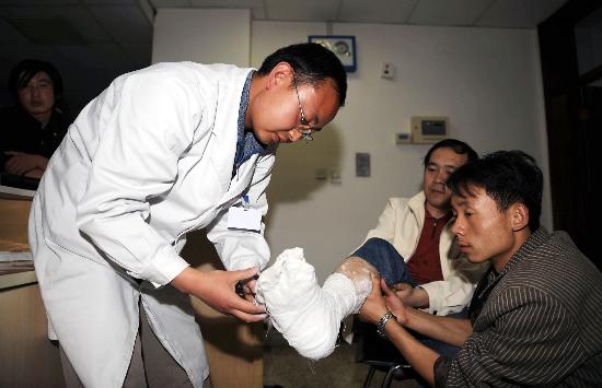 圖文:甘肅天水醫院醫生在為地震中受傷群眾包紮