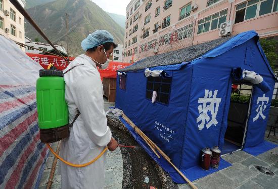 图文一名工作人员在给救灾帐篷外喷消毒液