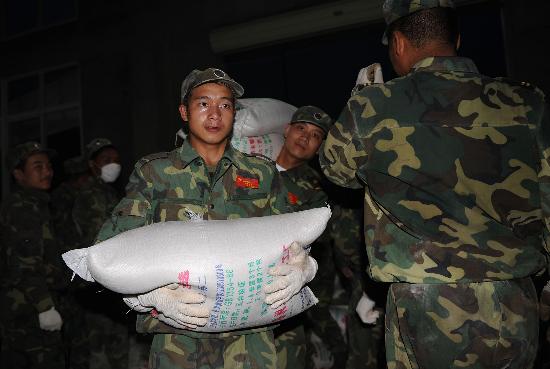 图文:战士们正在搬运供应给灾区群众的大米