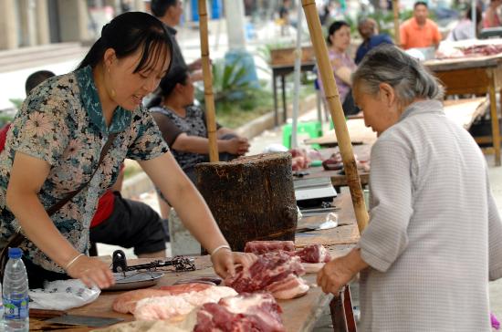 图文:四川平武县一位老人在农贸市场买肉