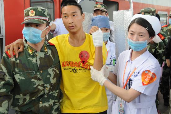 图文:医务人员和武警搀扶一名刚下火车的伤员