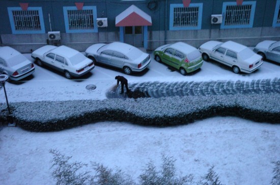 北京石景山區一居民小區內,居民在打掃小區道路上的積雪.