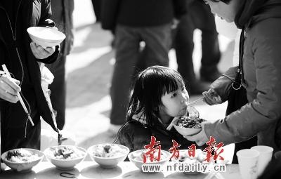 图为昨日一名女孩在品尝"敛巧饭".新华社发