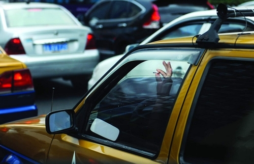 8月5日,芙蓉中路,車窗留了一條縫,司機手指掐著菸頭探出窗外,彈出菸灰