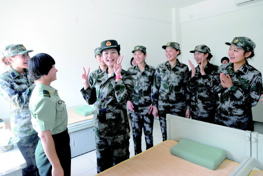 5日,幾名女新兵走進軍營,借老兵的軍帽戴上先威風一下.