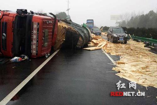 长常高速一货车雨天发生侧滑木板材散落一地