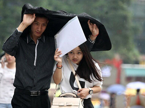 市民用衣服遮雨(图片来源:重庆日报)