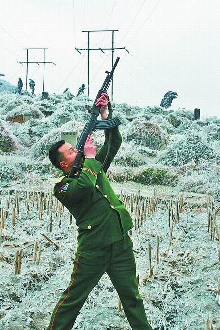 武警持冲锋枪击碎电网覆冰