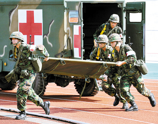 8月19日,在韩国首都首尔南面一体育场,韩国军医在演习中抬着担架奔跑.