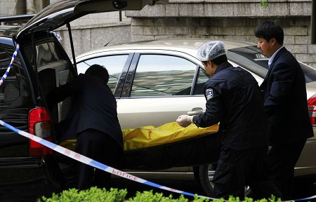 警察和殡仪馆的工作人员将尸体运离现场.本版图片 早报记者 赵昀