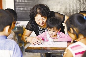 图② 胡永锋和孩子们一起做游戏(8月24日摄).