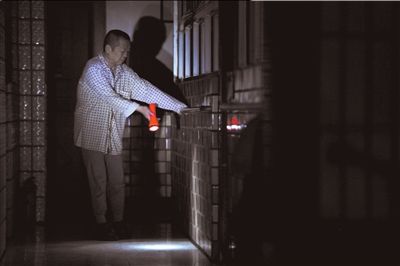 一位老人黑暗中起夜,摸着墙边的栏杆小心翼翼地行走.