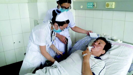 乘客孙居业躺在病床上接受雾化治疗. 本报记者 宋佳摄