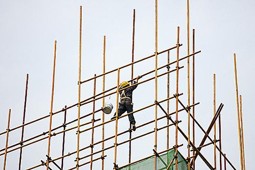 2008年4月23日 关山附近某建筑工地,一位建筑工人扛着一根钢筋管只身