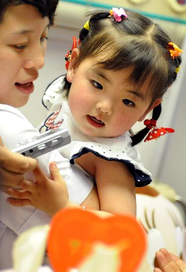 图文:宋馨懿在看医院赠送的节日蛋糕