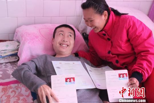 手捧中国和马来西亚两国的结婚证,李康宇和颜淑英露出幸福的笑容
