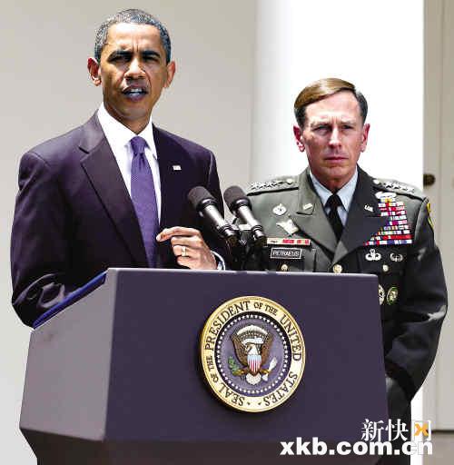凝重地在白宫草坪上宣布,提名彼得雷乌斯(右)为新一任驻阿美军司令