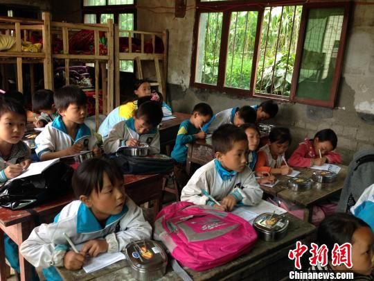 二、三年级共用一个教室,教室后方的高低床是为离家要走一个半小时以上的学生准备,18名学生与周廷猛共同吃住在学校。