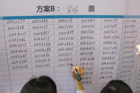 工作人员在公示牌上记录中奖号码