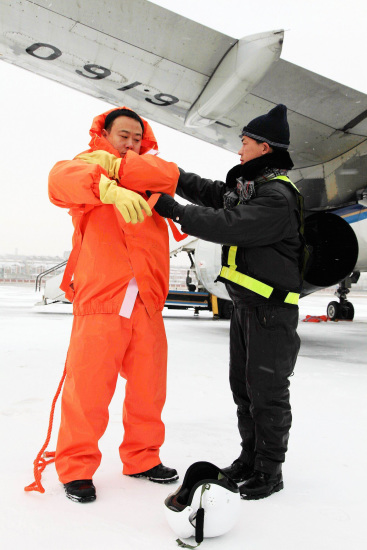 機務人員穿上特殊服裝準備給飛機除冰