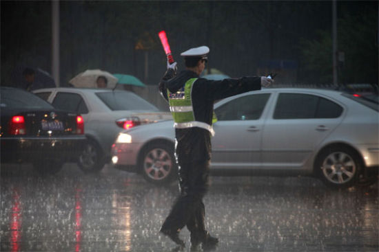 何建良拍摄的雨中执勤照片 西外大队民警在甘家口路口冒雨疏导交通